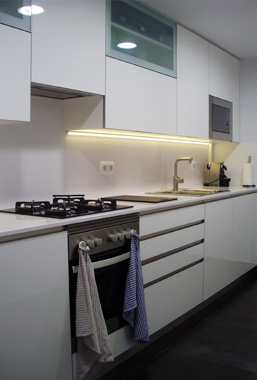 Cocina a medida de melamina lacada brillo con encimera de Silestone y tirador de gola realizada en Sant Andreu de Llavaneres